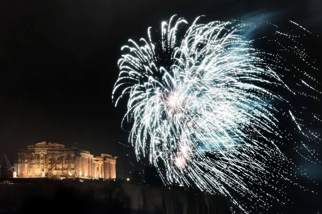 Fireworks explode above the ancient temple of Parthenon atop the Acropolis hill during the New Year celebrations in Athens on January 1, 2015. (Photo by Aris Messinis/AFP Photo)