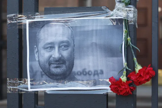 The Russian opposition journalist Arkady Babchenko portrait is seen on a fence of Russian embassy in Kiev, Ukraine, 30 May 2018. Russian opposition journalist Arkadiy Babchenko, who lived in Ukraine, was shot on 29 May 2018 in his Kiev home by three shots to his back and died from his wounds on the way to hospital, local media report. Babchenko was criticizing Russian authorities and writing about arrests of Crimean-Tatarian journalists in the Crimea after annexation of it by Russia. (Photo by Stepan Franko/EPA/EFE)