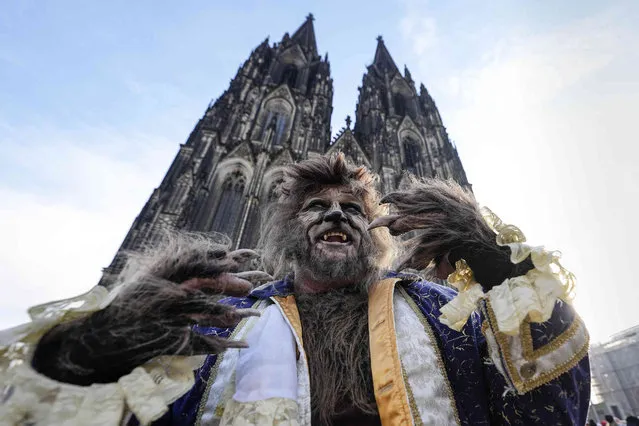 A reveller in a beast costume poses in front of the Cologne Cathedral at the start of the street carnival in Cologne, Germany, Thursday, February 16, 2023. Hundreds of thousands will celebrate the carnival without any coronavirus restrictions in the streets of the German carnival capital. (Photo by Martin Meissner/AP Photo)