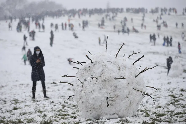 A giant snowball shaped as a coronavirus is seen on Parliament Hill on Hampstead Heath on January 24, 2021 in London, United Kingdom. Parts of the country saw snow and icy conditions as arctic air caused temperatures to drop. (Photo by Hollie Adams/Getty Images)