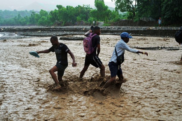 Residents wade through a flooded stream in the aftermath of Hurricane Melissa in Petit-Goave, Haiti, Thursday, October 30, 2025. (Photo by Odelyn Joseph/AP Photo)