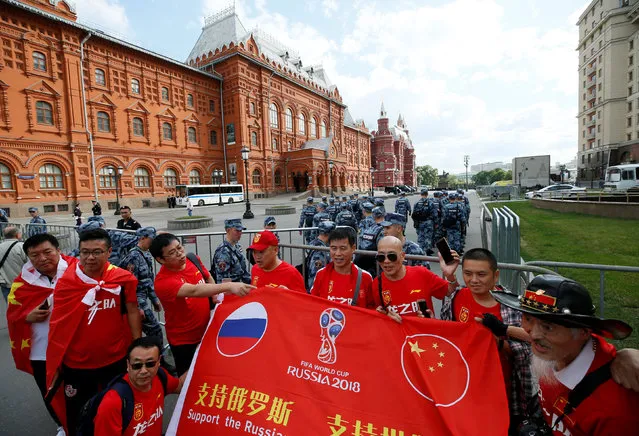 Chinese tourists pose for a picture near barriers, erected by officers of the Russian National Guard, on the eve of the 2018 FIFA World Cup in central Moscow, Russia June 13, 2018. (Photo by Gleb Garanich/Reuters)