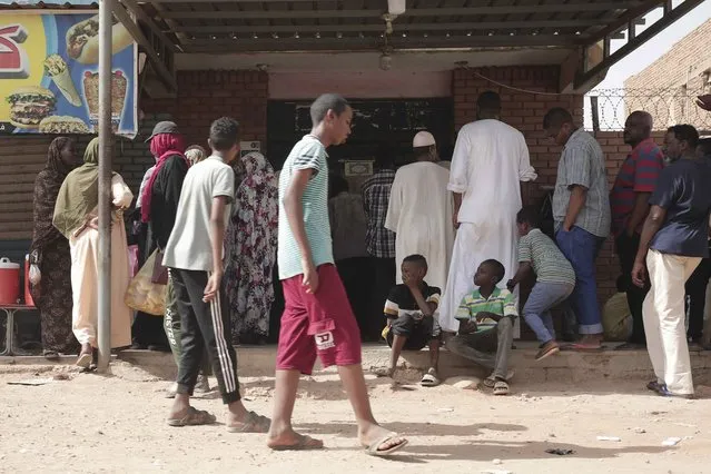 People line up in front of a bakery during a cease-fire in Khartoum, Sudan, Saturday, May 27, 2023. Saudi Arabia and the United States say the warring parties in Sudan are adhering better to a week-long cease-fire after days of fighting. (Photo by Marwan Ali/AP Photo)