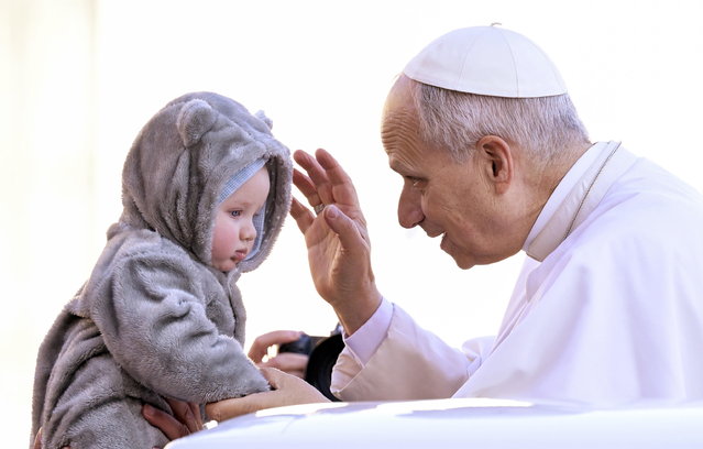 Pope Leo XIV blesses a child as he arrives to lead his weekly General Audience in Saint Peter's Square, Vatican City, 10 December 2025. (Photo by Riccardo Antimiani/EPA)