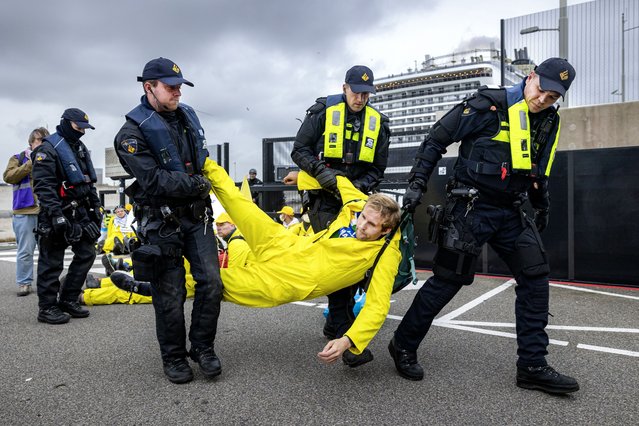 Activists from Extinction Rebellion are led away by police during the “Stop cruise ship pollution!” action during the arrival of cruise ship MSC Virtuosa at IJmuiden port, the Netherlands, 21 October 2024. According to the Extinction Rebellion, these ships cause a massive flow of tourists that affects local ecosystems, not just environmentally, but also economically for communities that depend on healthy oceans. (Photo by Hollandse Hoogte/EPA/EFE/Rex Features/Shutterstock)