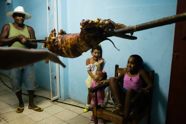 Children shriek as a roasted pig is brought into a birthday party in the neighborhood of Portuondo, in Santiago, Cuba on February 5, 2015. Santiago is the second largest city of Cuba. It is located in the south-eastern area of the island. (Photo by Sarah L. Voisin/The Washington Post)