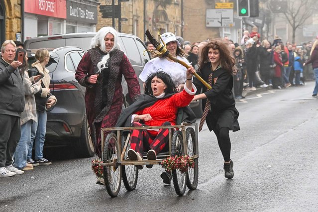 Competitors wearing fancy dress take part in the annual Lion Club charity pram race which is watched by a large crowd lining the Main Street at Crewkerne in Somerset, UK on Boxing Day on December 26, 2024. There were two races. The first for the juniors and the second with adults. (Photo by Graham Hunt/Alamy Live News)