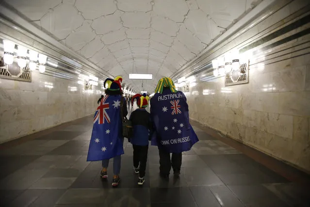 A Colombian family who lives in Australia wears flags supporting the Australian team as they walk inside a subway station in Moscow, Russia, during the 2018 soccer World Cup, Friday, June 15, 2018. (Photo by Rebecca Blackwell/AP Photo)