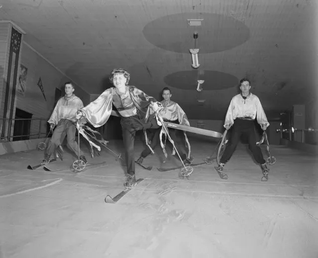 Edith Toon of East Milton, Mass., slides down slope on one ski as she and others perform a “ski ballet” at Bob Johnson's indoor Ski School at Newton Corner, Mass., December 2, 1947. The students in the background are, left to right: Frank A. Day III, of Newton and Walter McCann, of Waltham, Mass. The trio are part of a large group of avid skiers who can't wait until the natural white stuff starts falling outside. (Photo by AP Photo)