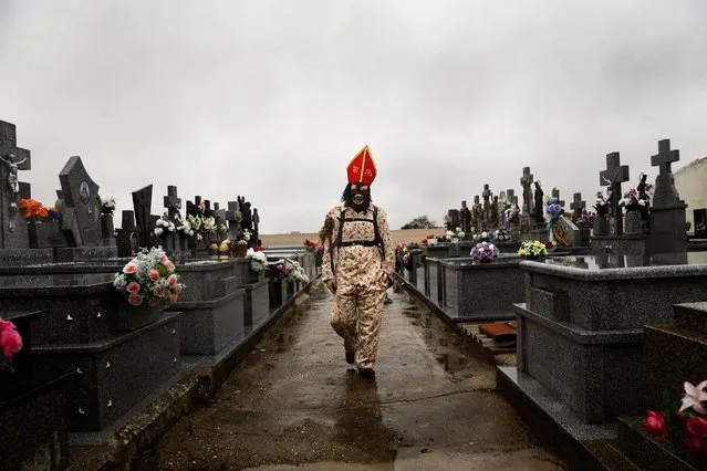 In this February 2, 2015 picture, a member of the Endiablada brotherhood walks trough the cemetery after paying respect to their deceased fellow believers and relatives during the “Endiablada” traditional festival in Almonacid Del Marquesado, Spain. (Photo by Daniel Ochoa de Olza/AP Photo)