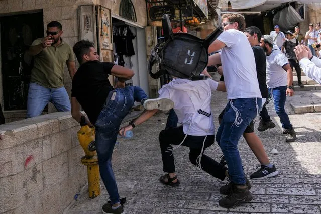 Palestinians and Jewish youths clash in Jerusalem's Old City as Israelis mark Jerusalem Day, an Israeli holiday celebrating the capture of the Old City during the 1967 Mideast war. Sunday, May 29, 2022. Israel claims all of Jerusalem as its capital. But Palestinians, who seek east Jerusalem as the capital of a future state, see the march as a provocation. Last year, the parade helped trigger an 11-day war between Israel and Gaza militants. (Photo by Ariel Schalit/AP Photo)