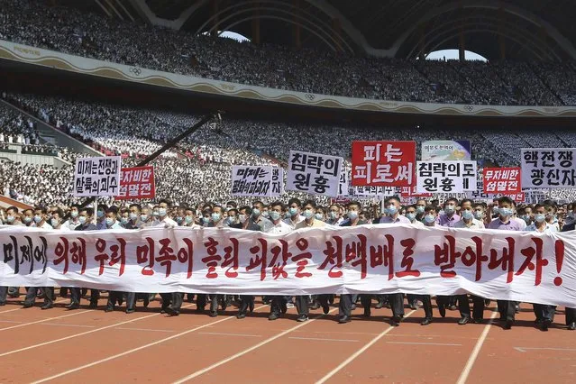 Pyongyang people take part in a demonstration after a mass rally to mark what North Korea calls “the day of struggle against U.S. imperialism” at the May Day Stadium in Pyongyang, North Korea Sunday, June 25, 2023. The signs read “Let us make the U.S. imperialists pay dearly for the blood shed by Korean nation!”, “The U.S. is the chieftain of war and massacre”, “merciless annihilation”, “The U.S is the destroyer of peace”, “chieftain of aggression”, “blood to blood” and “nuclear war maniac”.  (Photo by Jon Chol Jin/AP Photo)