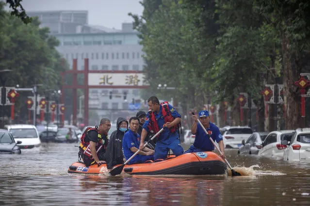 Rescue workers in a boat go through a flooded street in a neighbourhood where days of heavy rain from remnants of Typhoon Doksuri have caused heavy damage in Beijing, China on August 1, 2023. (Photo by Thomas Peter/Reuters)