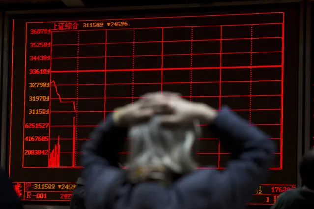 A woman reacts near a display board showing the plunge in the Shanghai Composite Index at a brokerage in Beijing, China, Thursday, January 7, 2016. Chinese stocks nosedived on Thursday, triggering the second daylong trading halt of the week and sending other Asian markets sharply lower as investor jitters rippled across the region. (Photo by Ng Han Guan/AP Photo)
