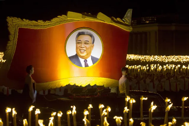 A float with a portrait of late North Korean leader Kim Il Sung passes by North Korean students taking part in a torch light march held in conjunction with the 70th anniversary of North Korea's founding day celebrations in Pyongyang, North Korea, Monday, September 10, 2018. (Photo by Ng Han Guan/AP Photo)