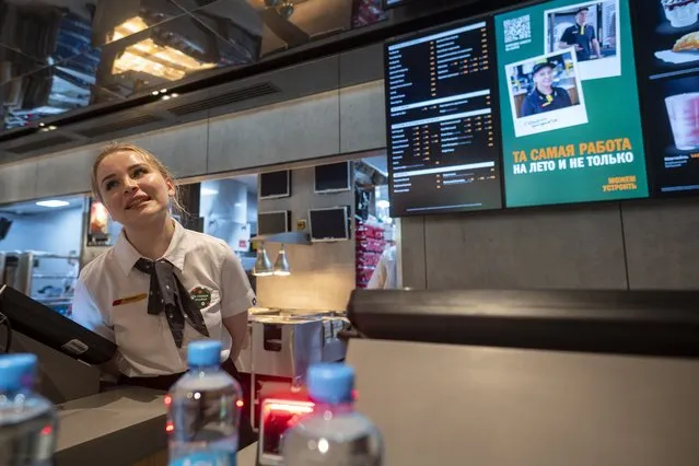 A staff member speaks with visitors at a newly opened fast food restaurant in a former McDonald's outlet in Bolshaya Bronnaya Street in Moscow, Russia, Sunday, June 12, 2022. The first of former McDonald's restaurants is reopened with new branding in Moscow. The corporation sold its branches in Russia to one of its local licensees after Russia sent tens of thousands of troops into Ukraine. (Photo by Dmitry Serebryakov/AP Photo)
