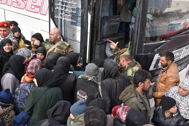 Syrians that evacuated the eastern districts of Aleppo gather to board buses, in a government held area in Aleppo, Syria in this handout picture provided by SANA on November 29, 2016. (Photo by Reuters/SANA)