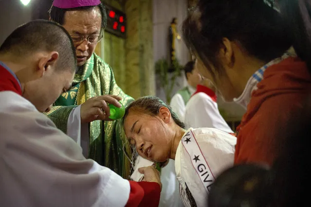 In this September 22, 2018, photo, Chinese bishop Joseph Li Shan, top left, baptizes a member of the faithful during a mass at the Cathedral of the Immaculate Conception, a government-sanctioned Catholic church in Beijing. The Vatican’s breakthrough agreement to give China some say over bishop appointments has critics accusing the church of caving in to the ruling Communist Party just as it is waging a sweeping crackdown on religion. Others say it’s an imperfect but much-needed step toward uniting Catholics in the world’s most populous country. (Photo by Mark Schiefelbein/AP Photo)