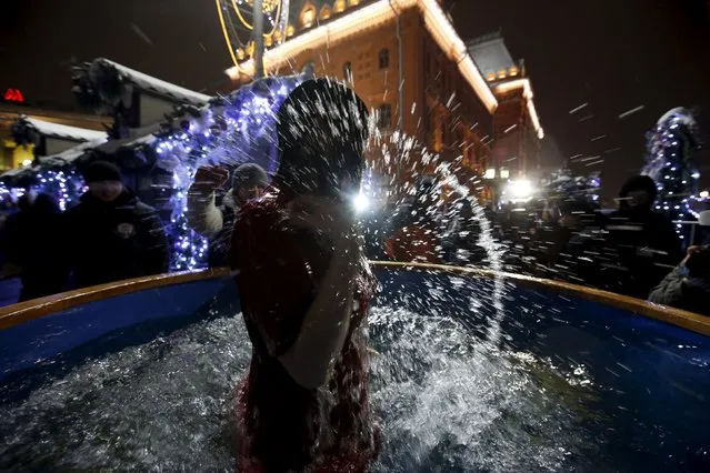 A believer makes a cross sign while taking a dip in a fountain on the eve of the Orthodox Epiphany in central Moscow, Russia, January 18, 2016. (Photo by Sergei Karpukhin/Reuters)