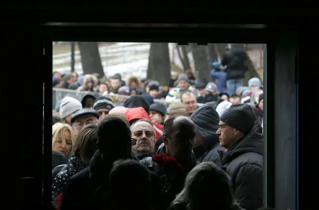 People stand in a line to attend a memorial service before the funeral of Russian leading opposition figure Boris Nemtsov in Moscow, March 3, 2015. Several hundred Russians, many carrying red carnations, queued on Tuesday to pay their respects to Boris Nemtsov, the Kremlin critic whose murder last week showed the hazards of speaking out against Russian President Vladimir Putin. REUTERS/Maxim Shemetov 