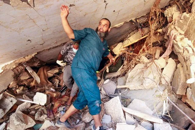 People search in the rubble of a building in a flash flood-damaged area in Derna on September 14, 2023. A global aid effort for Libya gathered pace on September 14 after a tsunami-sized flash flood killed at least 4,000 people, with thousands more missing, a death toll the UN blamed in part on the legacy of years of war and chaos. (Photo by Abdullah Doma/AFP Photo)