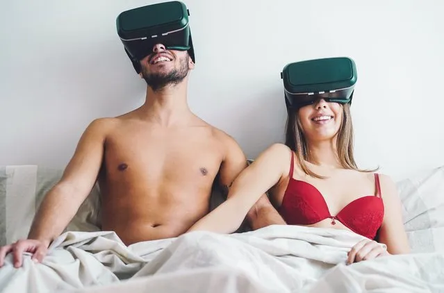 Young couple masturbating while using virtual reality glasses in the bed. Happy lover having sеx with vr goggles 3d in the bedroom. (Photo by Alamy Stock Photo)