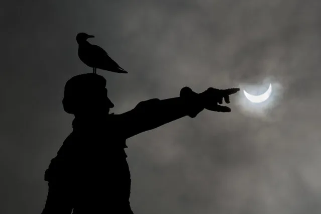 A partial solar eclipse of the sun is visible in Infante D Henrique square in Porto, North of Portugal, 20 March 2015. A Partial Solar Eclipse is seen in Europe, northern and eastern Asia and northern and western Africa on 20 March 2015. (Photo by Nuno Veiga/EPA)