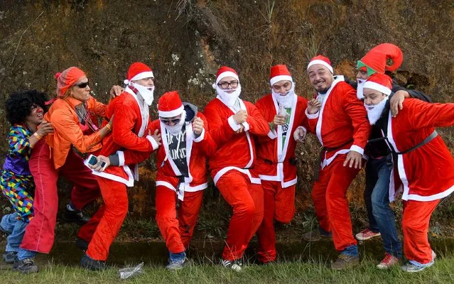 Participants fancy dressed as Santa Claus attend the XXVII Car Festival before going downhill in a homemade cart in the Santa Elena Municipality, near Medellin, Antioquia department, Colombia, on December 18, 2016. (Photo by Raul Arboleda/AFP Photo)