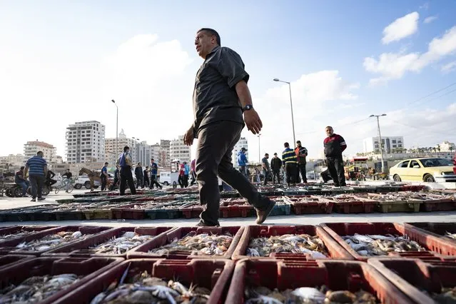 Lots of seafood are organized on the ground as buyers browse the day's catch at auction after a limited number of boats were allowed to return to the sea following a cease-fire reached after an 11-day war between Hamas and Israel, in Gaza City, Sunday, May 23, 2021. (Photo by John Minchillo/AP Photo)