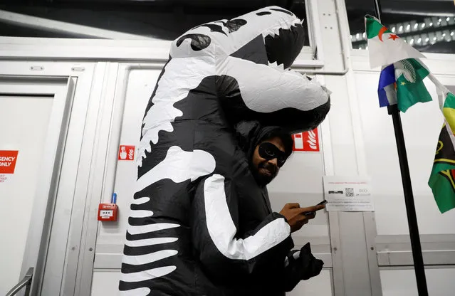 A man dressed like a dinosaur is seen prior to the “Colossal Fossil” award, offered by environmental activists from the The Climate Action Network (CAN), which is given to the country deemed to have done its best to block progress in the negotiations or in the implementation of the Paris Agreement, during the COP24 UN Climate Change Conference 2018 in Katowice, Poland December 13, 2018. (Photo by Kacper Pempel/Reuters)