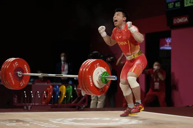 Chen Lijun of China celebrates after winning the gold medal and setting an Olympic record in the men's 67kg weightlifting event, at the 2020 Summer Olympics, Sunday, July 25, 2021, in Tokyo, Japan. (Photo by Luca Bruno/AP Photo)