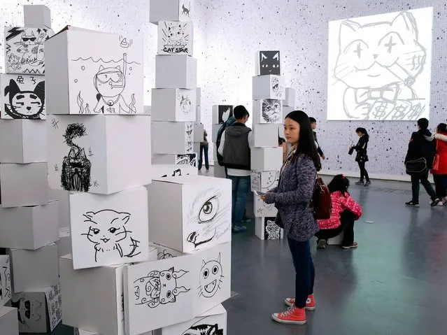 Visitors attend the opening of the “100,000 Cats Project” art show at the 798 art district in Beijing, China, 04 April 2015. The art show is a public art experiment sponsored by the Life-Fun Studio that aims to observe the diversity created by individuals under the circumstance of mobile internet, and discovers a different way of communication between people. The project has collected more than 300,000 cat paintings from mobile internet by now. (Photo by Wu Hong/EPA)