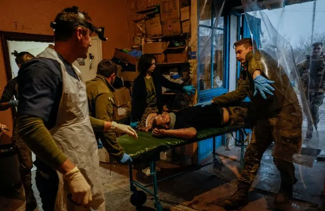 Medics of the the 47th “Magura” Separate Mechanized Brigade help a Ukrainian serviceman, who was recently wounded in the town of Avdiivka, inside a medical stabilisation point, amid Russia's attack on Ukraine, in an undisclosed location, Donetsk region, Ukraine on November 16, 2023. (Photo by Alina Smutko/Reuters)