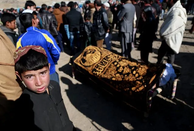 Afghan people attend the funeral ceremony of a victim who was killed in twin bombings that targeted the Parliament building in Kabul, Afghanistan, January 11, 2017. Reports state a double suicide attack near the Afghani parliament in Kabul on January 10 killed at least 30 people and injured another 80. (Photo by Hedayatullah Amid/EPA)