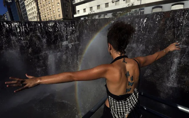A demonstrator reacts at a fountain that emulates the Iguazu Falls during a rally commemorating the 12th anniversary of the social and economic crisis that led to Argentine former President Fernando De la Rua's resignation, in Buenos Aires December 20, 2013. (Photo by Marcos Brindicci/Reuters)