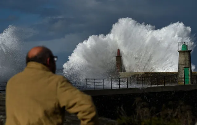 A man looks at waves as they crash against a lighthouse in the northern Spanish village of Viavelez, Spain January 13, 2017. (Photo by Eloy Alonso/Reuters)