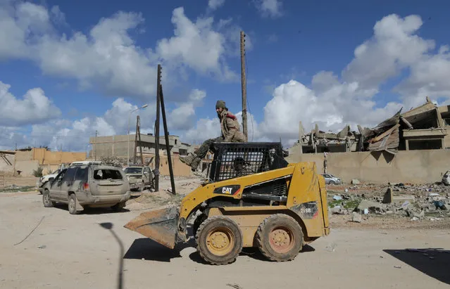 Members of East Libyan forces ride a digger after taking control of Ganfouda district in Benghazi, Libya January 26, 2017. (Photo by Esam Omran Al-Fetori/Reuters)