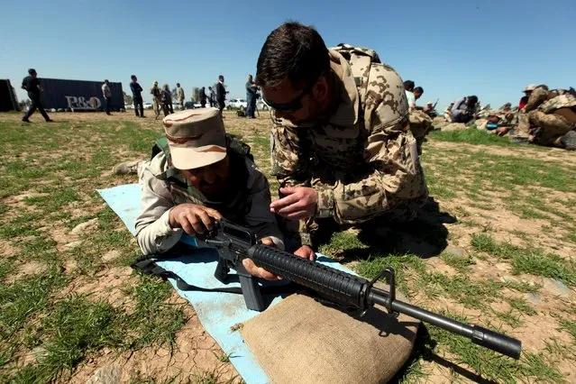 An officer from the coalition forces (R) gives advice to Kurdish Peshmerga fighters during a training session by coalition forces in a training camp in Erbil, north of Iraq, March 9, 2016. (Photo by Azad Lashkari/Reuters)