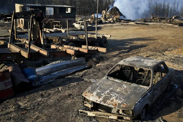 Scorched trees, vehicles and debris cover the landscape of a sawmill consumed by wildfires in the community Santa Olga, Chile, Tuesday, January 31, 2017. The fires have been raging in central and southern Chile, fanned by strong winds, hot temperatures and a prolonged drought. (Photo by Esteban Felix/AP Photo)