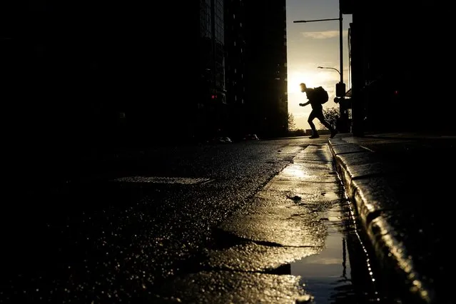 A pedestrian crosses a street at sunset in the city centre during a lockdown to curb the spread of a coronavirus disease (COVID-19) outbreak in Sydney, Australia, September 14, 2021. (Photo by Loren Elliott/Reuters)