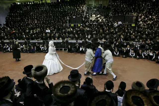 An ultra-Orthodox Jewish bride takes part in the "mitzva tantz", the custom in which relatives dance in front of the bride after her wedding ceremony, in Netanya, Israel early March 16, 2016. Thousands took part in the wedding of the grandson of Rabbi Yosef Dov Moshe Halberstam, religious leader of the Sanz Hasidic dynasty and the granddaughter of the religious leader of Toldos Avraham Yitzchak Hasidic dynasty, in Netanya on Tuesday night. (Photo by Baz Ratner/Reuters)