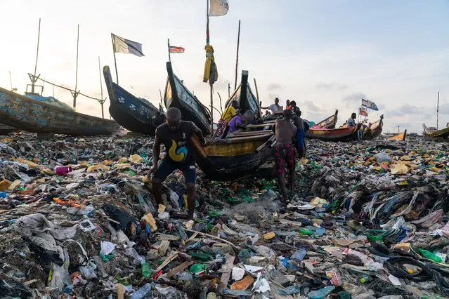 A sea of plastic and clothes waste covers the beach in the coastal fishing community of Jamestown in Accra, Ghana on October 14, 2021. (Photo by Muntaka Chasant/Rex Features/Shutterstock)