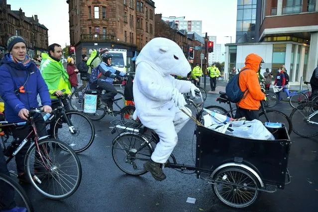 A demonstrator wearing a polar bear costume rides a bike during a protest, as the UN Climate Change Conference (COP26) takes place, in London, Britain, November 6, 2021. (Photo by Henry Nicholls/Reuters)