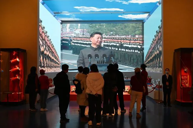 People look at a video of Chinese President Xi Jinping reviewing a military parade, at the Museum of the Communist Party of China in Beijing on February 29, 2024, ahead of next week’s opening of the annual session of China’s legislature. (Photo by Greg Baker/AFP Photo)
