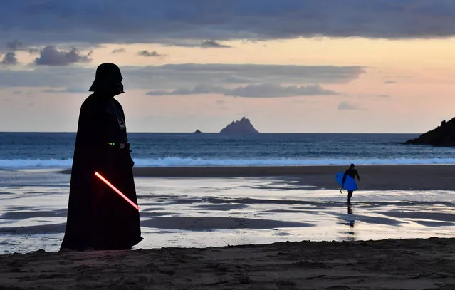 Garrison Ireland Leigon member John O'Dwyer dressed as the character Darth Vader looks out towards Skellig Michael island on May 4, 2019 in Portmagee, Ireland. The latest Star Wars movies such as The Last Jedi have featured the famous Skellig Michael islands situated off the coast of the small Irish fishing village. The May the Fourth Star Wars festival is taking place in the small County Kerry village for the second year running as millions of fans worldwide celebrate the science fiction series. The quiet costal setting has seen a sharp rise in the number of tourists and fans visiting the area. (Photo by Charles McQuillan/Getty Images)