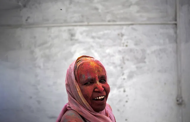 A widow daubed in colours takes part in the Holi celebrations organised by non-governmental organisation Sulabh International at a ashram at Vrindavan, in the northern state of Uttar Pradesh, India, March 22, 2016. Traditionally in Hindu culture, widows are expected to renounce earthly pleasure so they do not celebrate Holi. But women at the shelter for widows, who have been abandoned by their families, celebrated the festival by throwing flowers and coloured powder. Holi, also known as the Festival of Colours, heralds the beginning of spring and is celebrated all over India. (Photo by Anindito Mukherjee/Reuters)