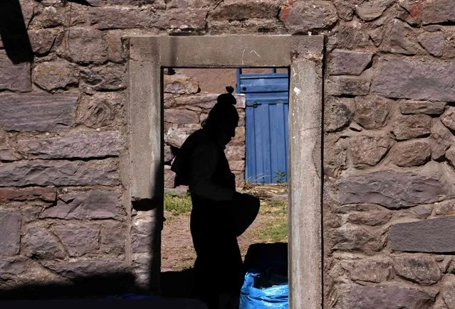 A resident is silhouetted inside the courtyard of his home, in the Taquile Island of Puno, Peru, Saturday, October 30, 2021. (Photo by Martin Mejia/AP Photo)