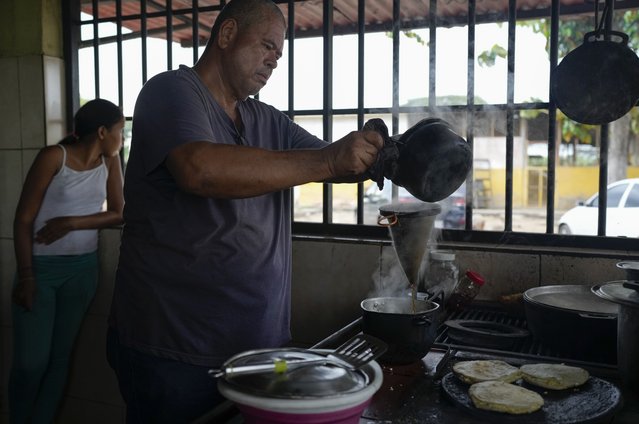 Julio Alvarez brews coffee at the kitchen of his farm in the outskirts of Barinas, Venezuela, Sunday, December 5, 2021. Alvarez hasn't sold any milk in about two years even though the cows at his farm in rural northwestern Venezuela are milked around dawn every day. Serious fuel shortages and rationing made it impossible for him to transport it, except in plastic containers strapped around a motorcycle, and forced him to start making much-less-profitable cheese. (Photo by Ariana Cubillos/AP Photo)