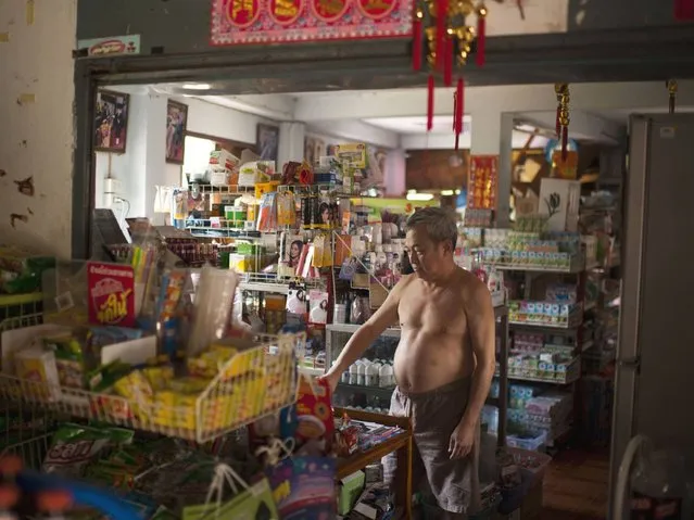 Kowit Ew, a gold buyer, weighs gold in his food store in Wang Kaeo in Lampang. (Photo by Borja Sanchez-Trillo/Getty Images)