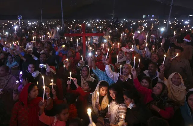 Pakistani Christians hold candles during a celebration for Christmas, in Lahore, Pakistan, Wednesday, December 22, 2021. (Photo by K.M. Chaudary/AP Photo)